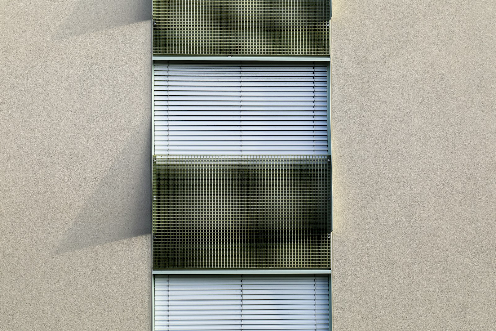 White venetian blinds fitted to the windows of a building, one form of solar shading