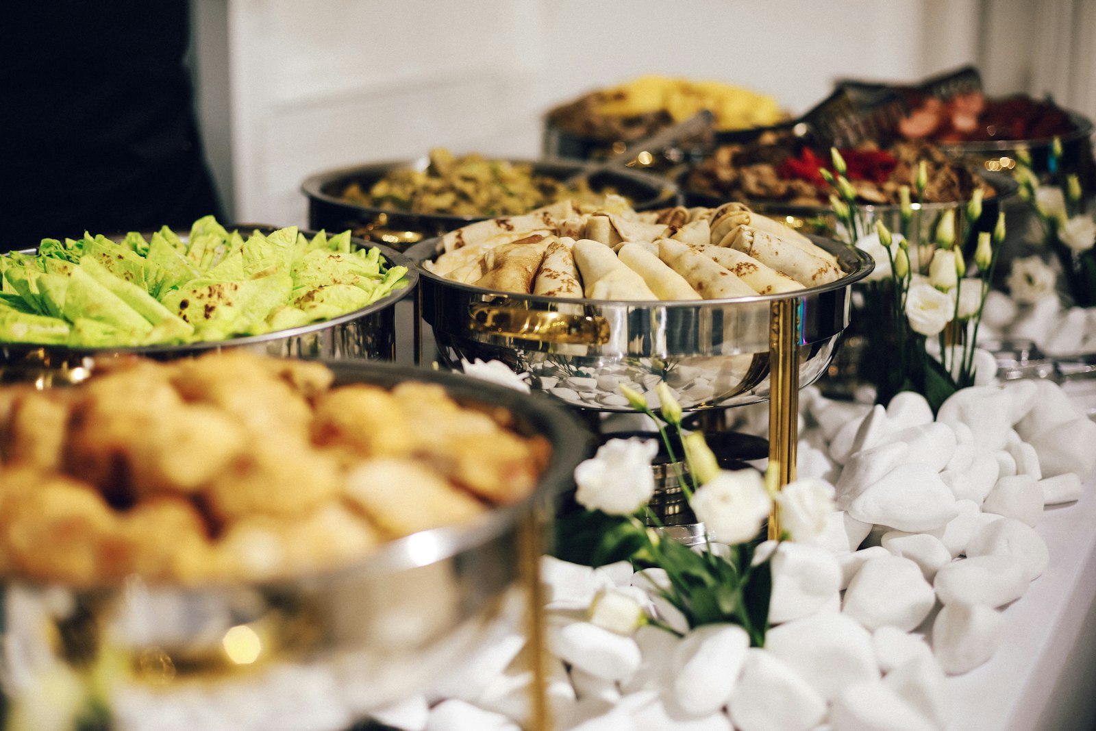 Buffet table with silver chafing dishes of prepared food, an option for conference catering