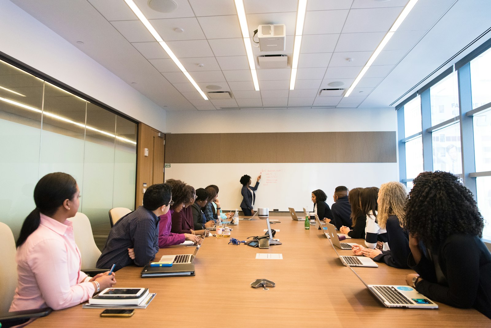 Colleagues around a conference table listening to a woman speaking during a workplace session