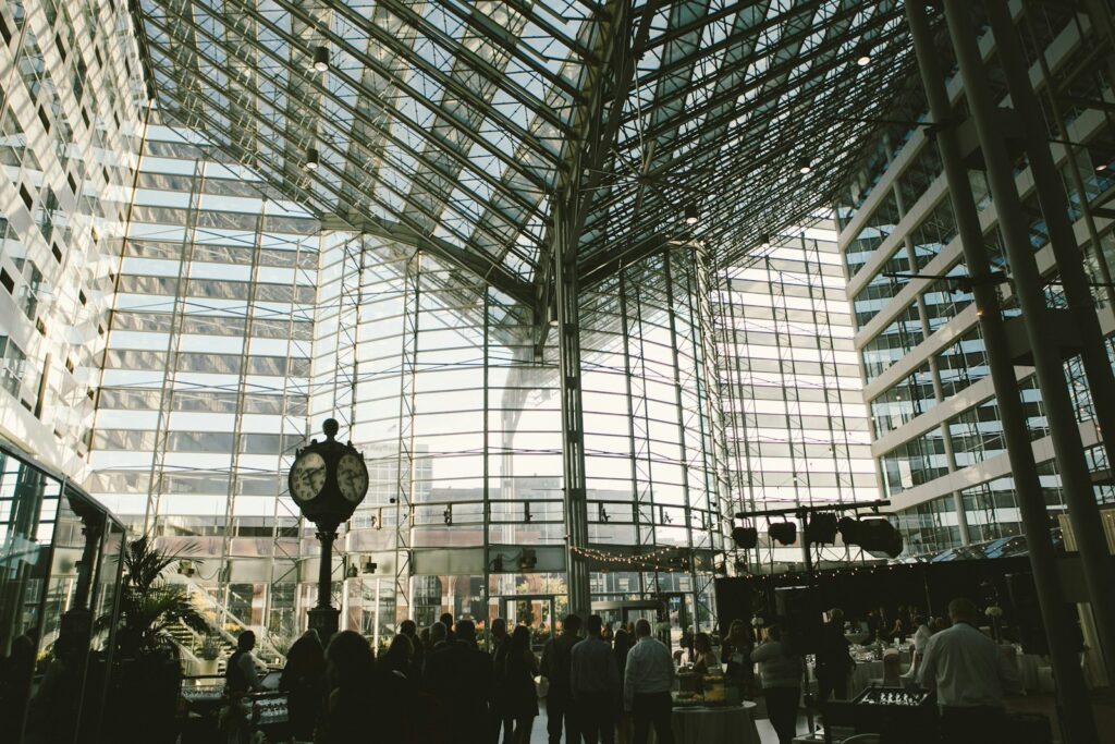 People walking inside a building during the day, with a wedding reception in the atrium